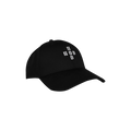 Détail broderie croix blanche sur casquette noire, accessoire streetwear sombre.